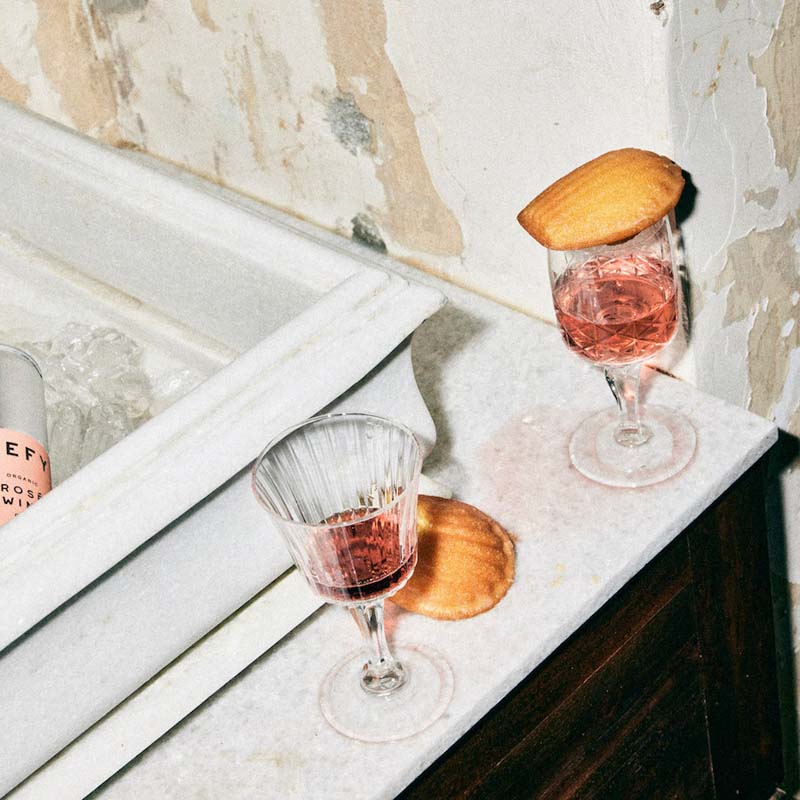 Crystal glasses of DEFY Italian rosé wine; vegan organic and delicious next to a marble sink.